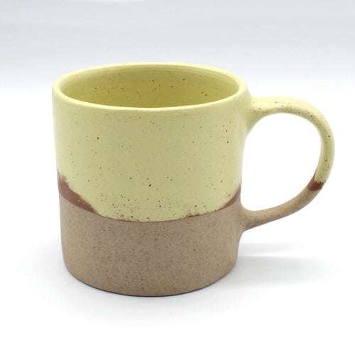 A single Daorueng handmade ceramic mug on a white background. Two colour mug, speckled clay on the bottom, paremesan yellow on the top two thirds, with two colours on the handle.