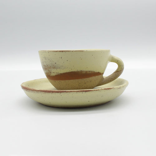 side on view of handmade espresso cup and saucer from Thailand, yellow with natural clay rustic look