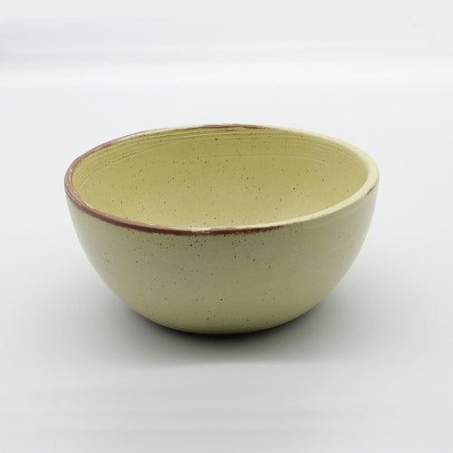 Side on view of handmade ceramic soup bowl from Thailand, yellow and natural clay rustic
