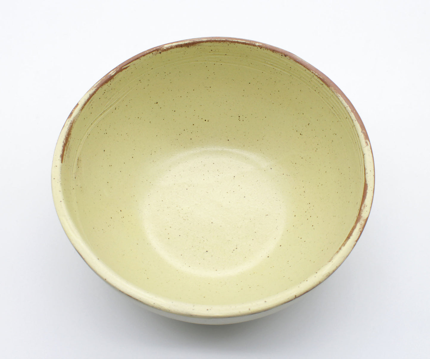 Handmade ceramic soup bowl from Thailand, yellow and natural clay rustic on a white background