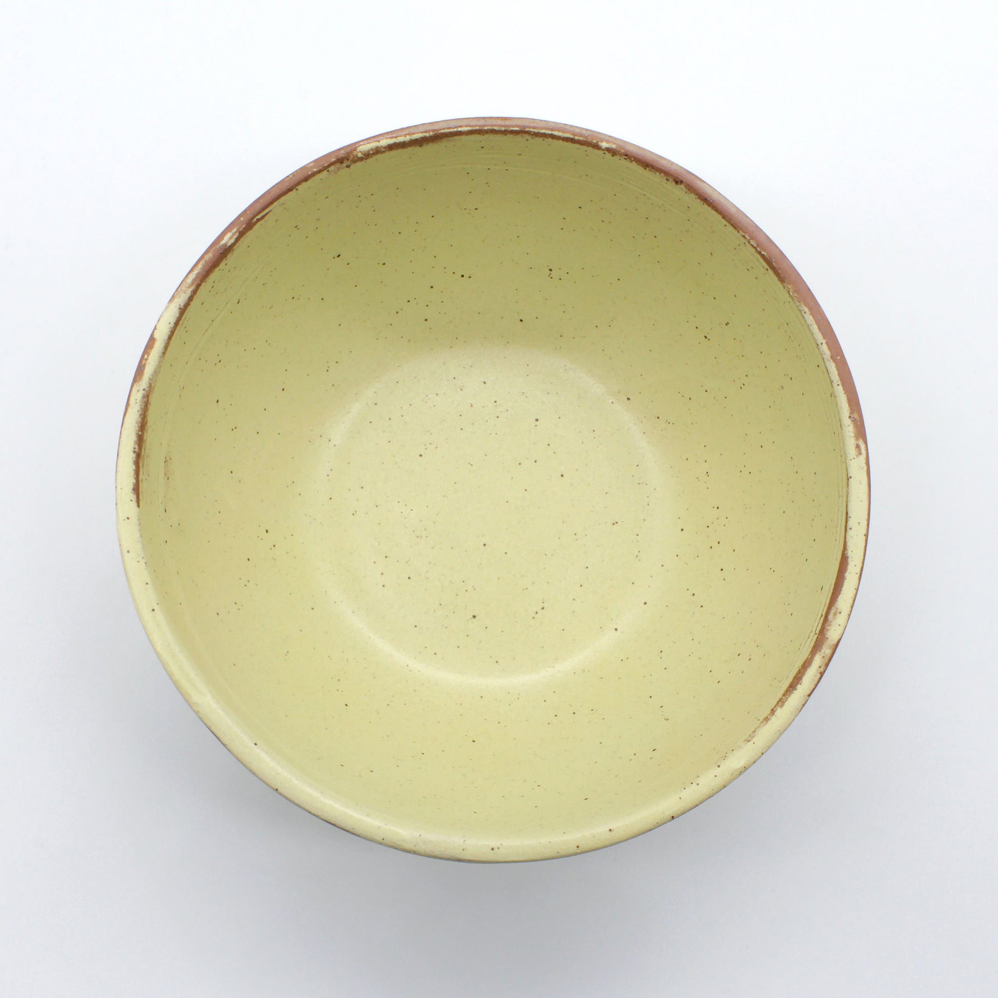 Top view of handmade ceramic soup bowl from Thailand, yellow natural clay rustic