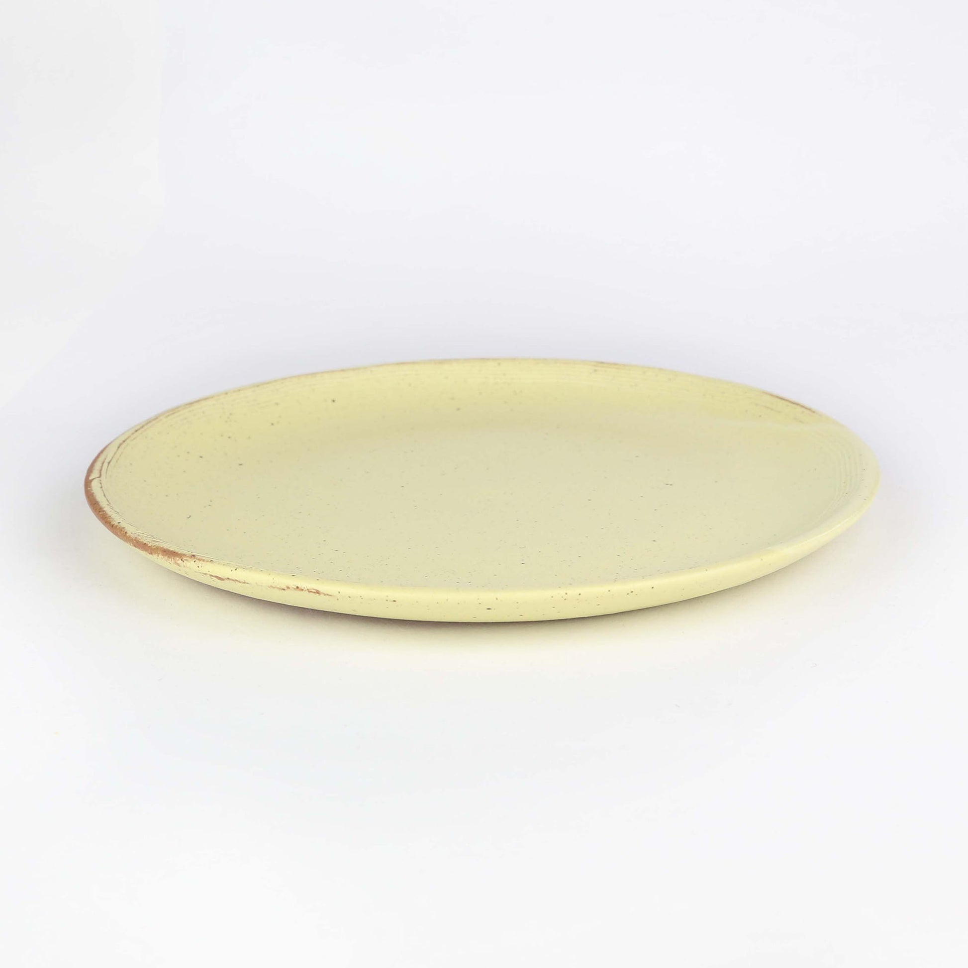 Side view of beautiful handmade ceramic side plate from Thailand, yellow and natural clay rustic