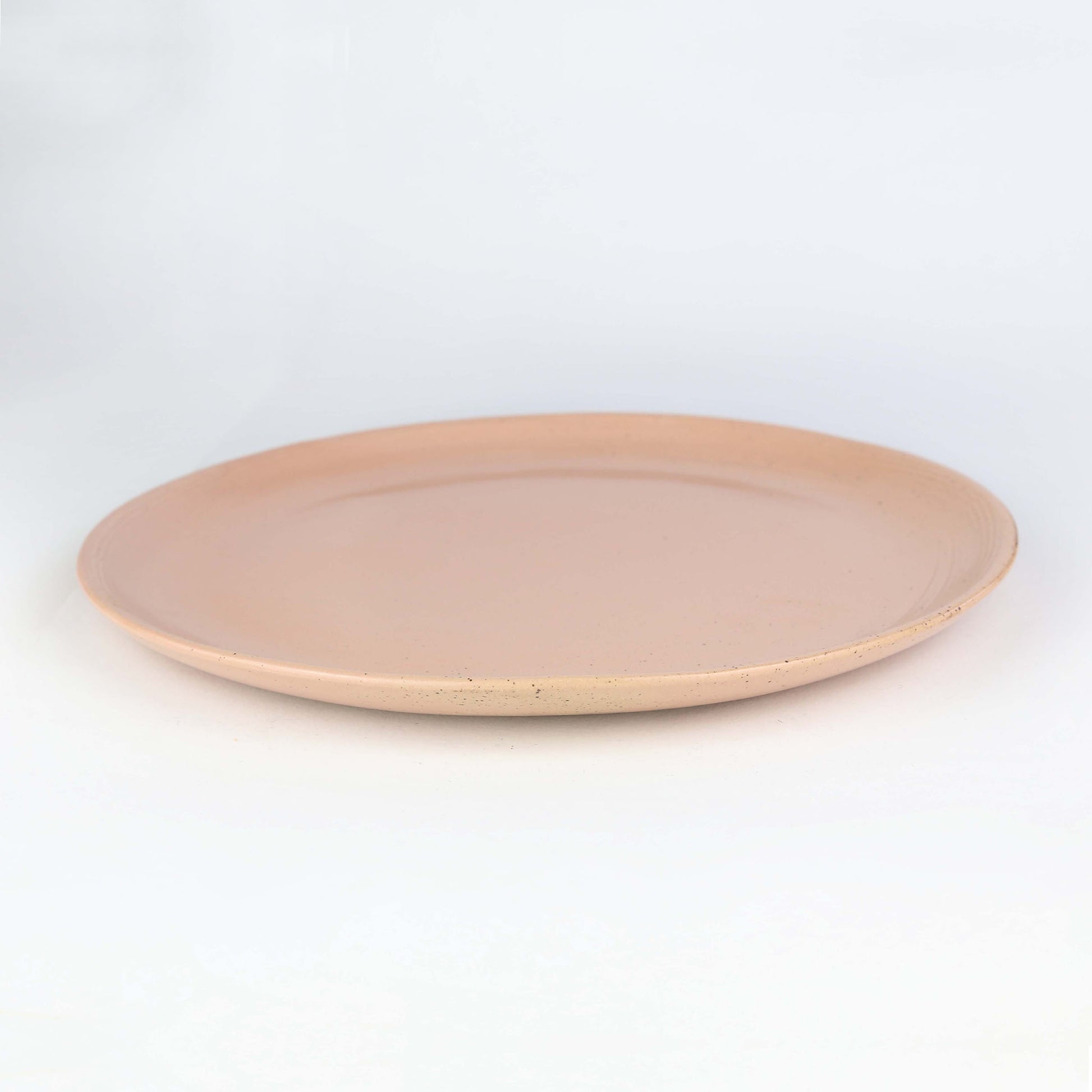 Side view of Isariya dinner plate. The is our peach collection with random touches of clay combining with the peach to make an eye-catching piece.