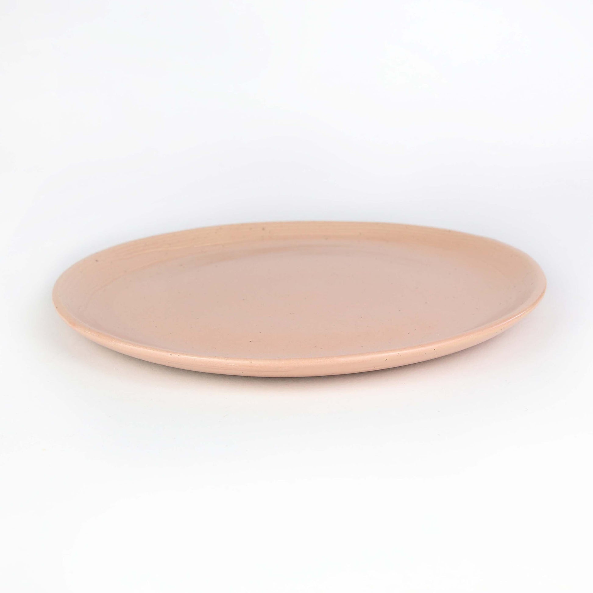 Side view of Isariya side plate. The is our peach collection with random touches of clay combining with the peach to make an eye-catching piece.