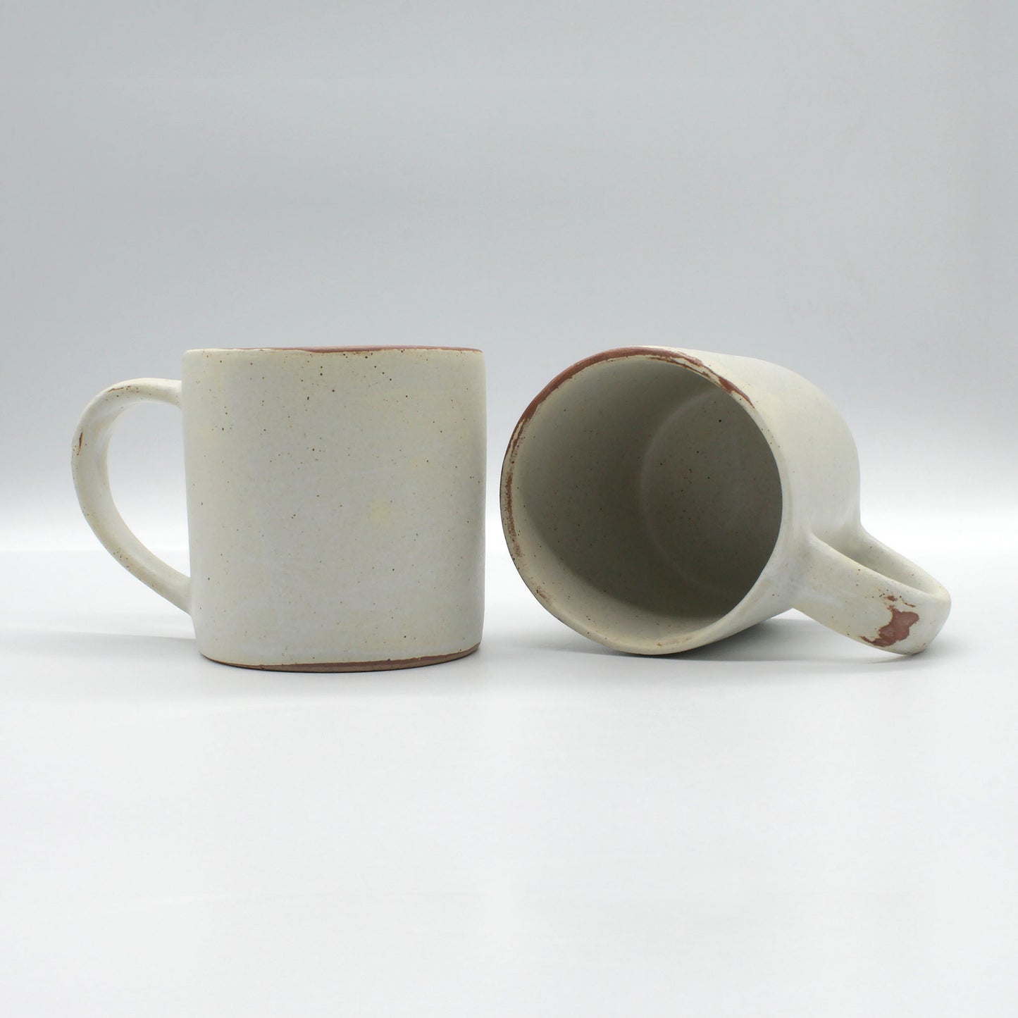 Handmade, antique white coffee mug with speckles of clay.