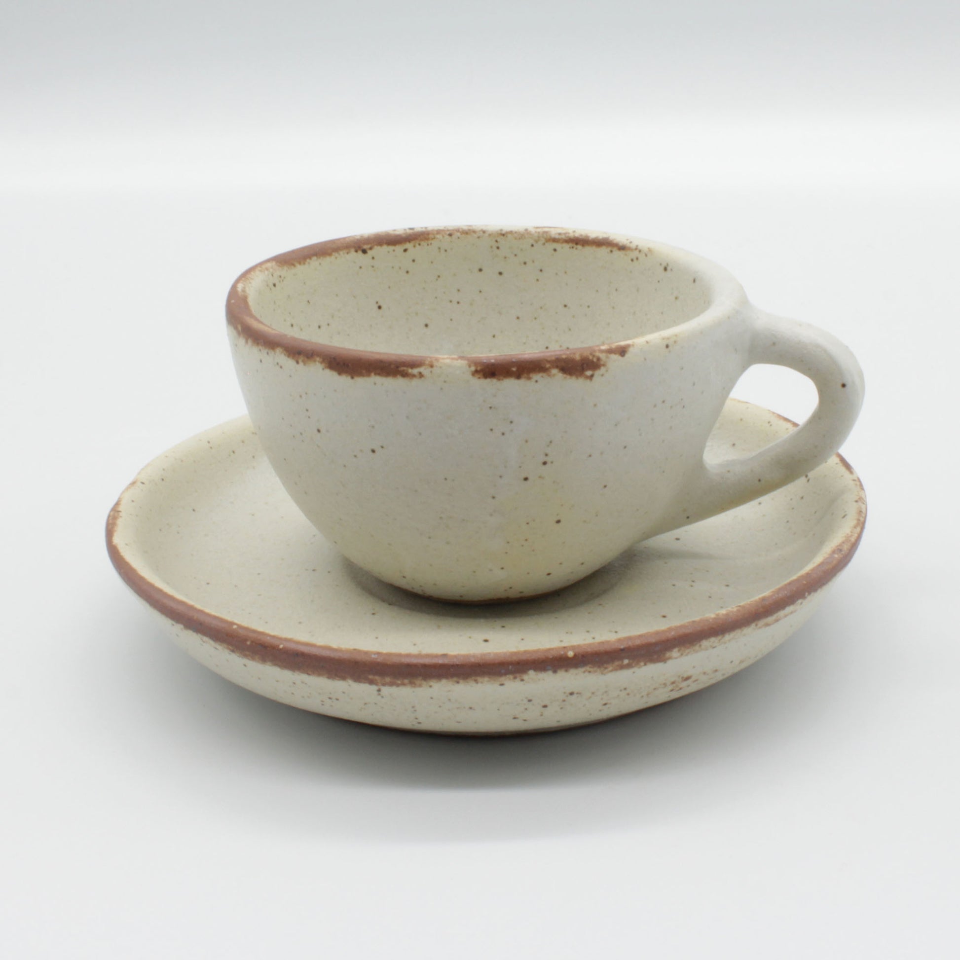 Lotus espresso cup and saucer - antique white in colour with touches of clay colour