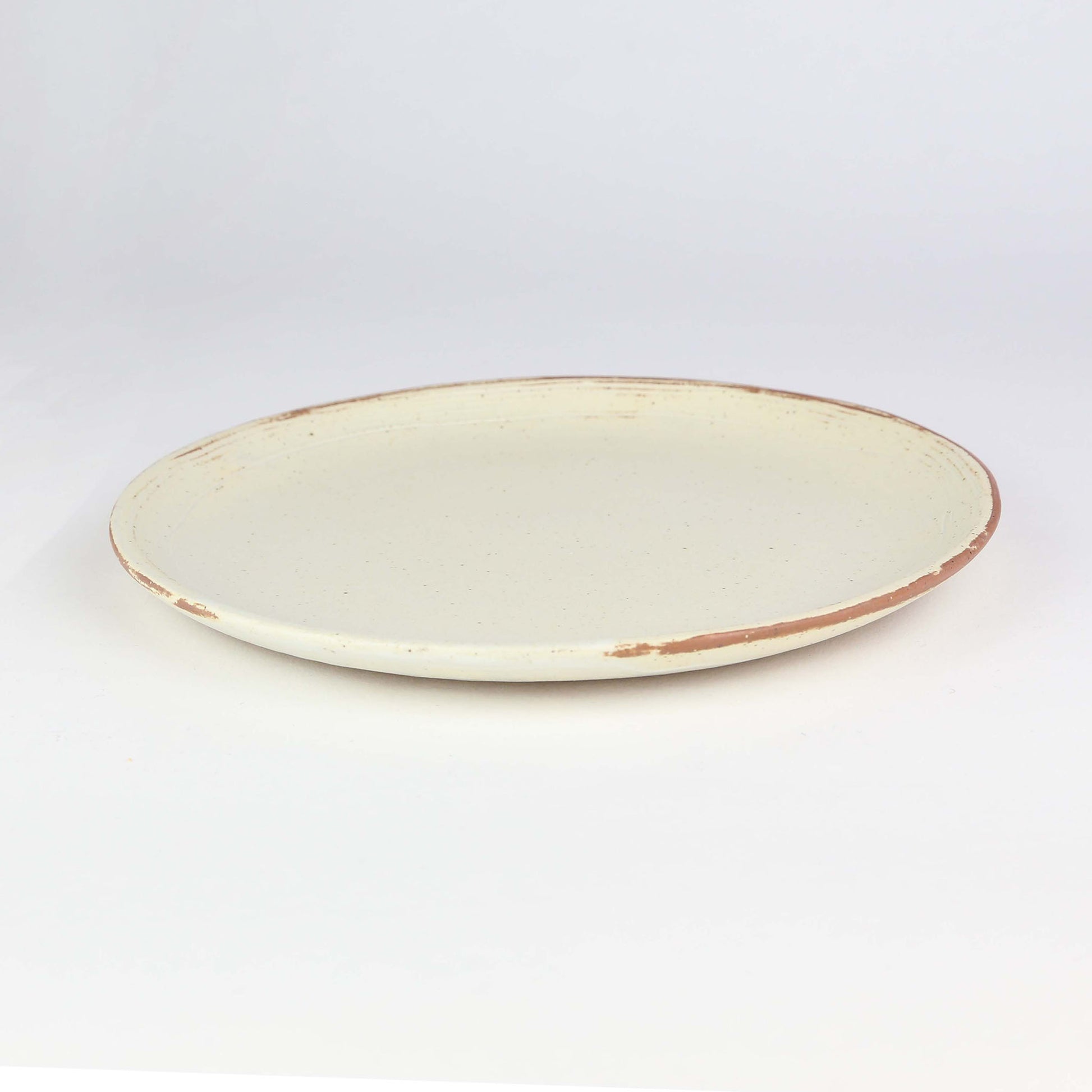 Side view of side plate from our Lotus collection – made of naturally speckled clay creating fine black spots in the texture of the clay