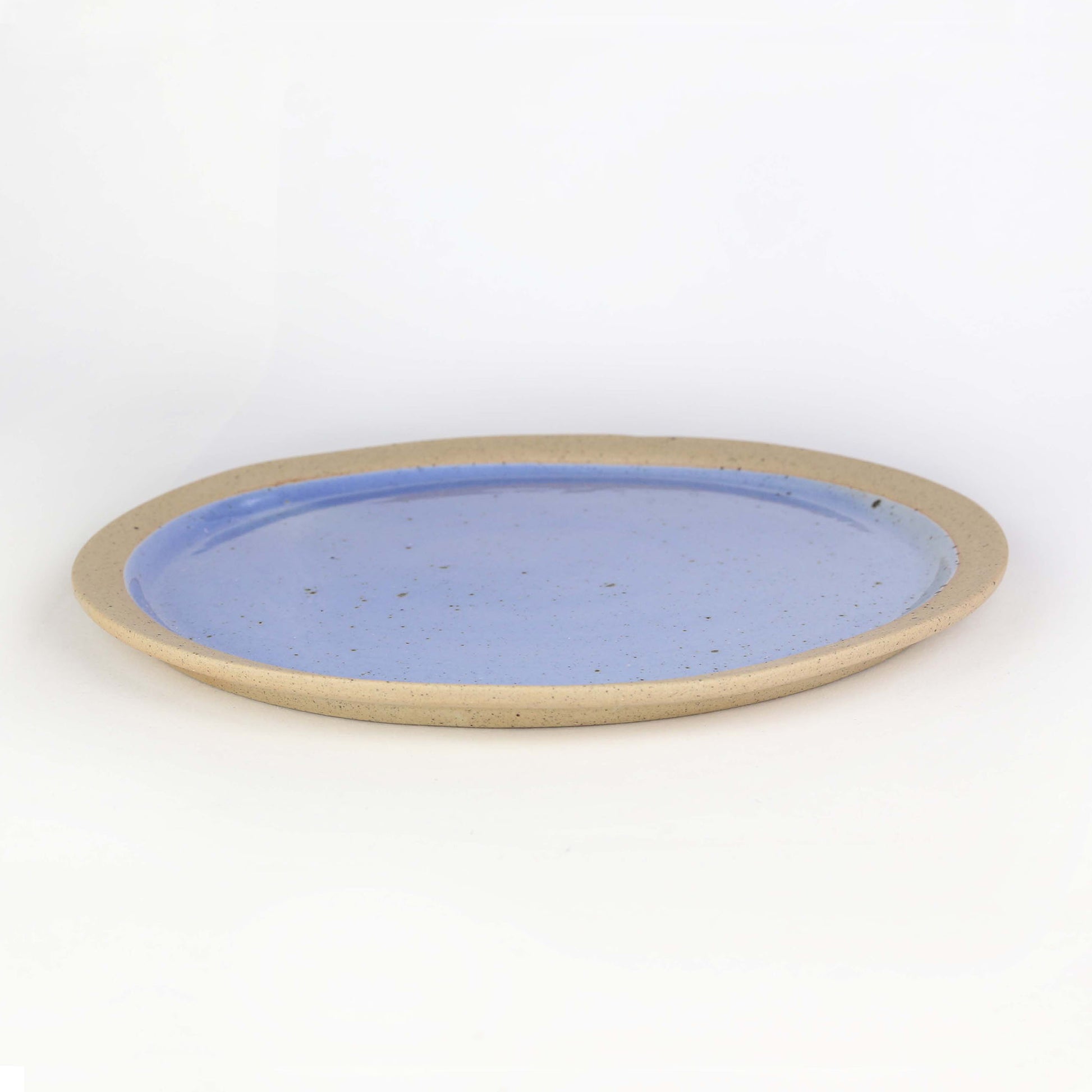 Side view of dinner plate from our Napa collection. Cornflower blue and glaze encased in the bare clay texture.