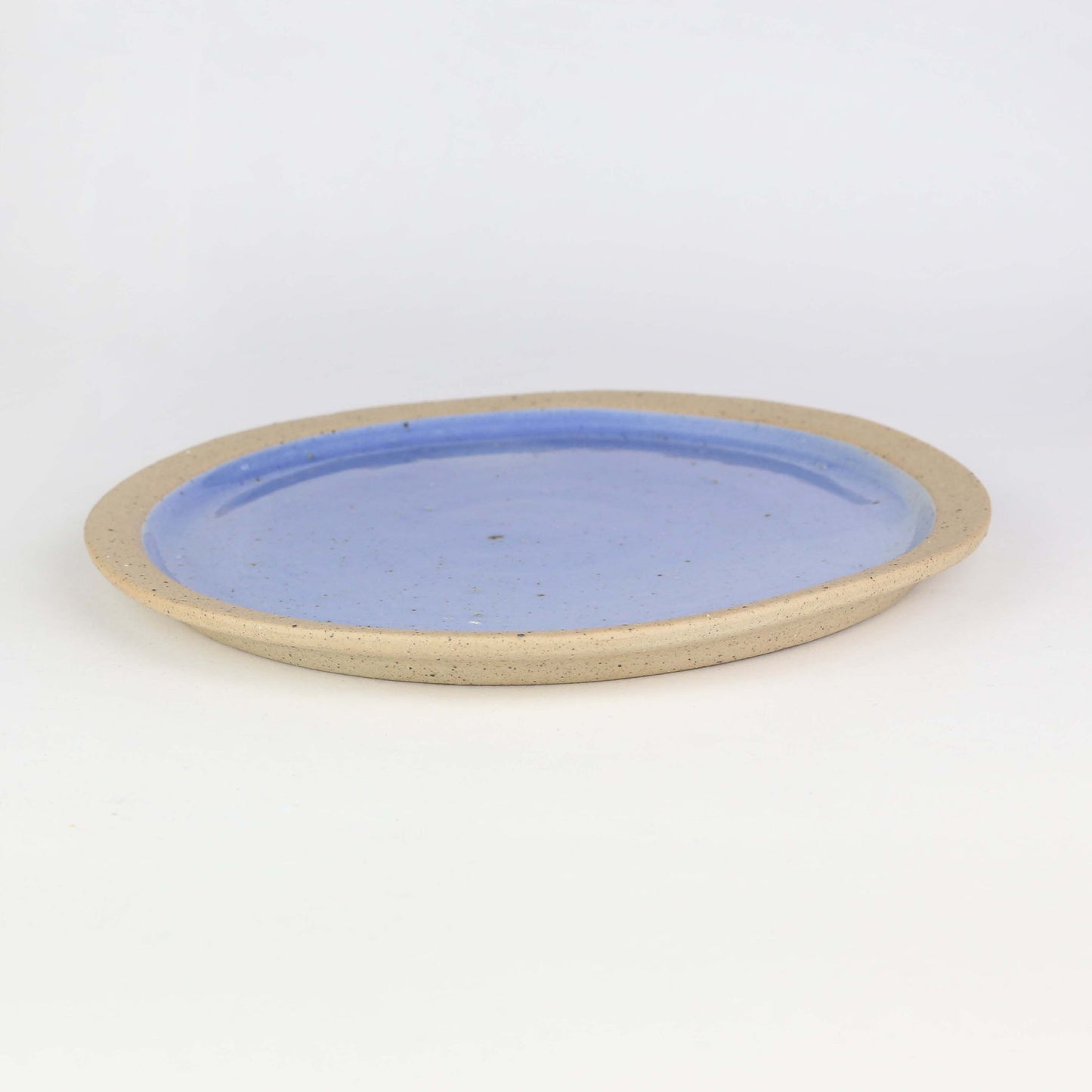 Side view of side plate from our Napa collection. Cornflower blue and glaze encased in the bare clay texture.